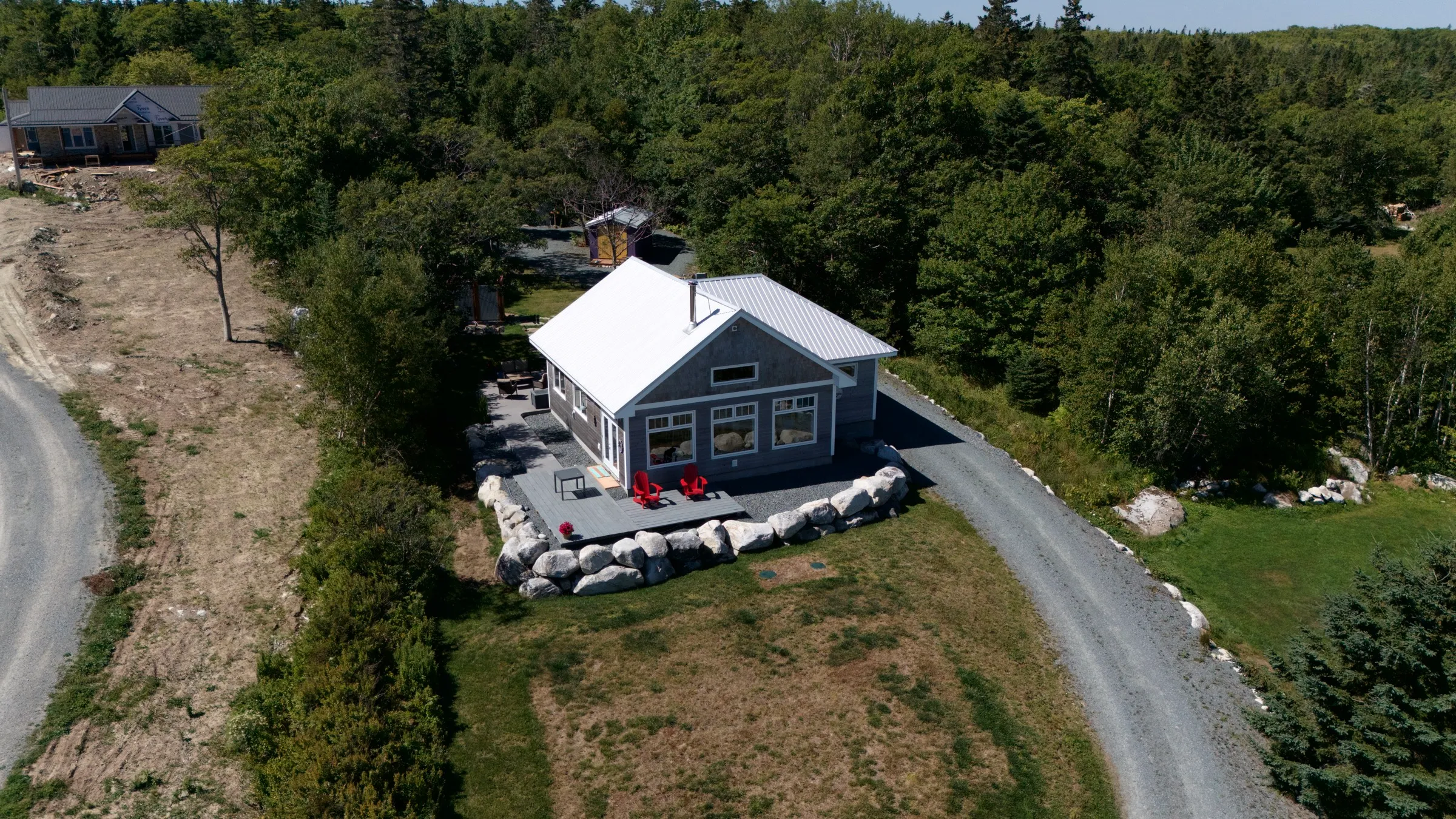 Aerial view of the cottage on its clearing, ringed by South Shore woods