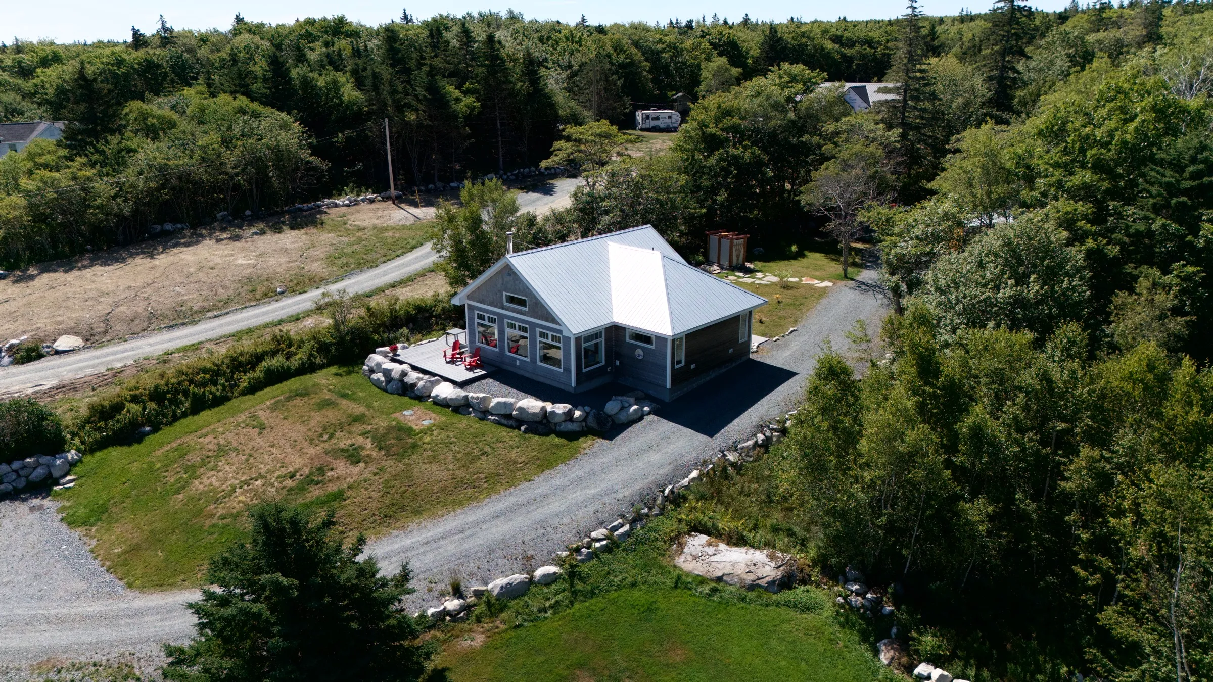 Aerial view of the cottage and gravel drive tucked into the trees near Port Mouton