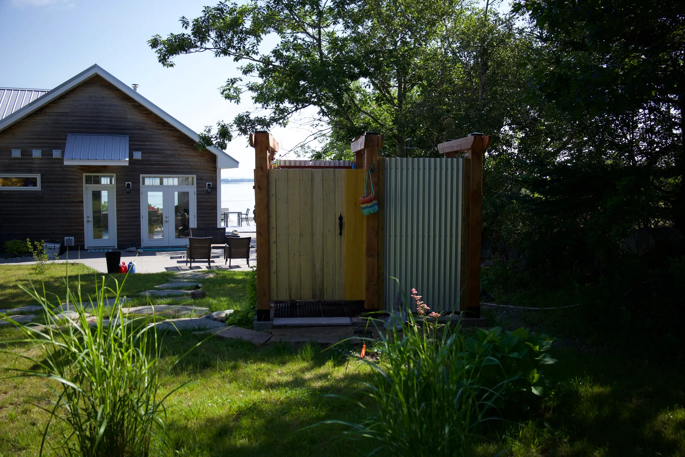 Private outdoor shower beside the cottage at Hi Tides, with the deck and bay just behind