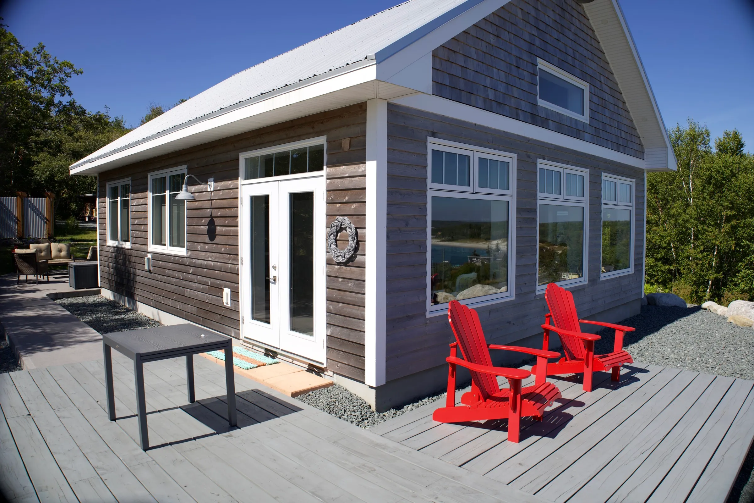 Side deck looking back toward the grey-blue cedar-shingle cottage